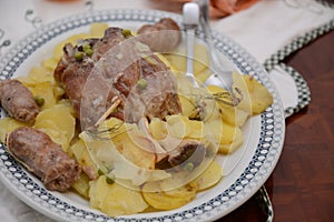 Traditional dish pork shank with potatoes oinon peans in baken on table in restaurant lunch food