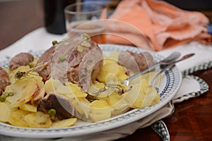 Traditional dish pork shank with potatoes oinon peans in baken on table in restaurant lunch food