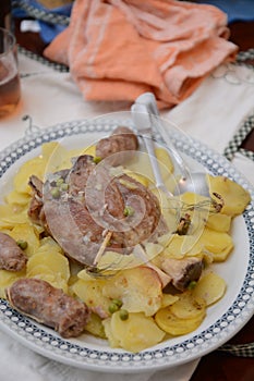 Traditional dish pork shank with potatoes oinon peans in baken on table in restaurant lunch food