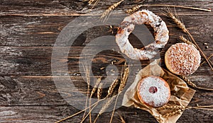 Traditional donuts with jam and appetizing cracknel on wooden background photo