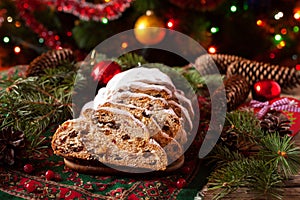 Traditional Dresdner German Christmas cake Stollen with raising, berries and nuts. Celebration decorations.