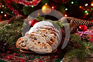 Traditional Dresdner German Christmas cake Stollen with raising, berries and nuts. Celebration decorations. photo