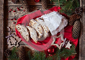 Traditional Dresdner German Christmas cake Stollen with raising, berries and nuts. Holiday xmas decorations.