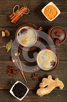 Traditional drink with spices,Indian masala chai tea with milk, ginger, anise and cinnamon on an old wooden table. cafe concept,