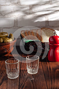 Traditional drink vodka in glasses, with a snack in the form of cold cuts and bacon, cucumbers, preservation. Russian festive