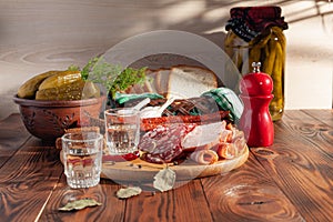 Traditional drink vodka in glasses, with a snack in the form of cold cuts and bacon, cucumbers, preservation. Russian festive