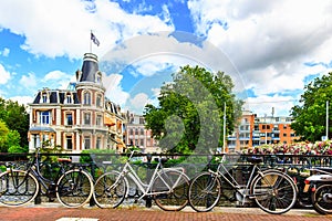 Traditional dutch bicycles parked along the street at Museumbrug bridges over canal. Amsterdam in summer, Netherlands, Europe.