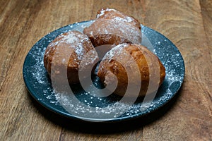 Traditional Dutch doughnut on a plate, with powder sugar on it. Called oliebollen in the Netherlands. Mostly eaten on New Year`s E