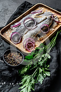 Traditional Dutch food herring with red onion. New season of herring called Hollandse nieuwe. Black background. Top view