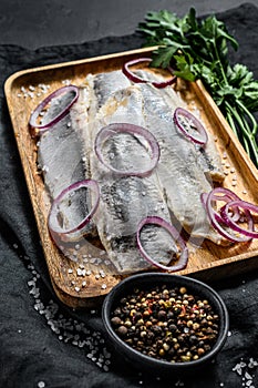 Traditional Dutch food herring with red onion. New season of herring called Hollandse nieuwe. Black background. Top view