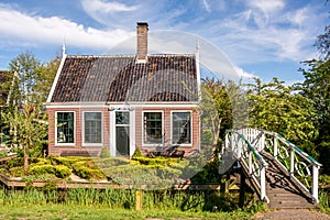 Traditional Dutch old house and garden. White bridge across the canal. Holland.