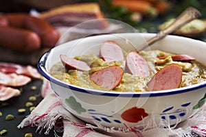 Traditional Dutch pea soup and ingredients on a rustic table