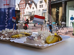 Traditional Dutch street food - fresh herring with onions and pickles