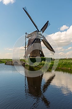 Traditional Dutch windmill on the bank of the canal in Kinderdijk, Netherlands, Holland, rural landscape, lifestyle