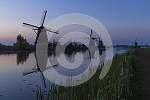 Traditional Dutch windmills with a colourful sky just before sunrise in Kinderdijk, The Netherlands