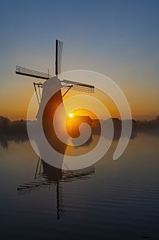 Traditional Dutch windmills with a colourful sky just before sunrise in Kinderdijk, The Netherlands