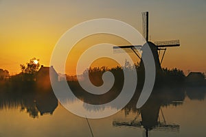 Traditional Dutch windmills with a colourful sky just before sunrise in Kinderdijk, The Netherlands