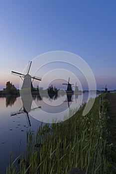 Traditional Dutch windmills with a colourful sky just before sunrise in Kinderdijk, The Netherlands