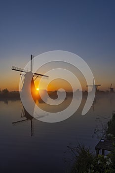 Traditional Dutch windmills with a colourful sky just before sunrise in Kinderdijk, The Netherlands