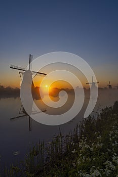 Traditional Dutch windmills with a colourful sky just before sunrise in Kinderdijk, The Netherlands