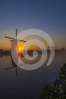 Traditional Dutch windmills with a colourful sky just before sunrise in Kinderdijk, The Netherlands