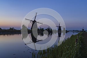 Traditional Dutch windmills with a colourful sky just before sunrise in Kinderdijk, The Netherlands