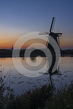 Traditional Dutch windmills with a colourful sky just before sunrise in Kinderdijk, The Netherlands