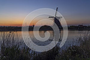 Traditional Dutch windmills with a colourful sky just before sunrise in Kinderdijk, The Netherlands