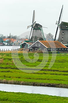 Traditional Dutch windmills and old farm house on river bank