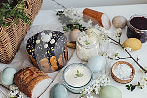 Traditional Easter basket food for festive dinner. Natural dyed easter eggs, stylish easter bread, ham, beets, butter, cheese on