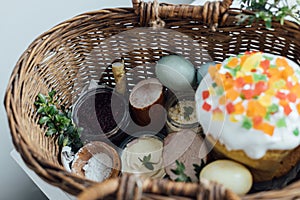 Traditional Easter basket. Natural dyed easter eggs, easter bread, ham, beets, butter, cheese in wicker basket decorated with