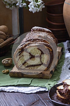Traditional Easter bread with chocolate and nut filling on a wooden background.