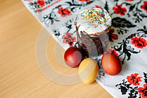 Traditional easter cake kulich Ukrainian style with colored eggs on painted towel