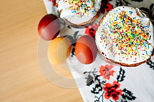 Traditional easter cake kulich Ukrainian style with colored eggs on painted towel