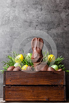 Traditional Easter chocolate bunny and eggs inside a wooden crate