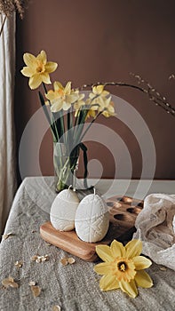 Traditional Easter decor.Burning soy candles in the shape of white eggs on a brown background