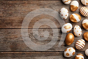 Traditional Easter eggs decorated with golden paint on wooden background