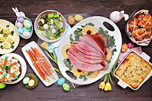 Traditional Easter ham dinner. Top down view table scene on a dark wood background. photo