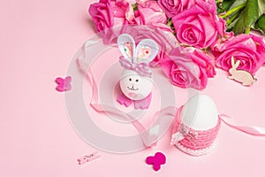 Traditional Easter symbols concept with cute rabbit from an egg, festive decor and gentle roses