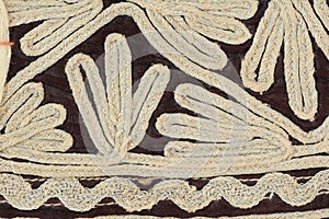 Traditional eastern hand made crafted curved lines embroidery fabric pattern close up