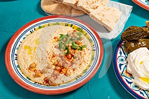 Traditional Eastern Mediterranean Arabic meal of flatbread, hummus, dolma and yoghurt, garnished with herbs and olive oil