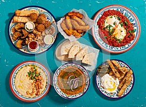 Traditional Eastern Mediterranean Moroccan hot breakfast of fried vegetables, halloumi, falafel, shakshuka, hummus, red lentil and