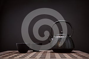 Traditional eastern teapot and teacups on wooden desk