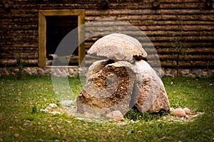 Traditional ecological rest. Large stones in the form of composition in the foreground. Wooden wall in the background