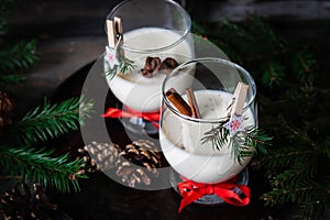 Traditional eggnog Christmas cocktail in a glass goblet decorated with New Year clothespin. Non-alcoholic option
