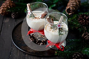 Traditional eggnog Christmas cocktail in a glass goblet decorated with New Year clothespin. Non-alcoholic option