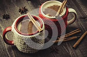 traditional eggnog in red and white mugs with cinnamon/traditional eggnog in red and white mugs with cinnamon on a dark