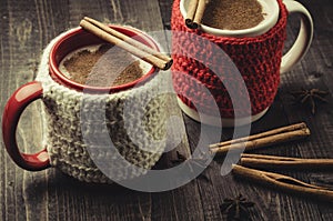 traditional eggnog in red and white mugs with cinnamon/traditional eggnog in red and white mugs with cinnamon on a dark