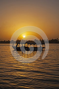 Traditional egyptian felluca sailing boat sailing on Nile at sunset