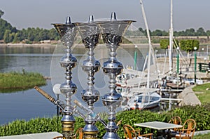 Traditional Egyptian shisha pipes with boats on the river Nile
